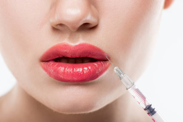 partial view of woman with syringe making beauty injection in lips, isolated on white